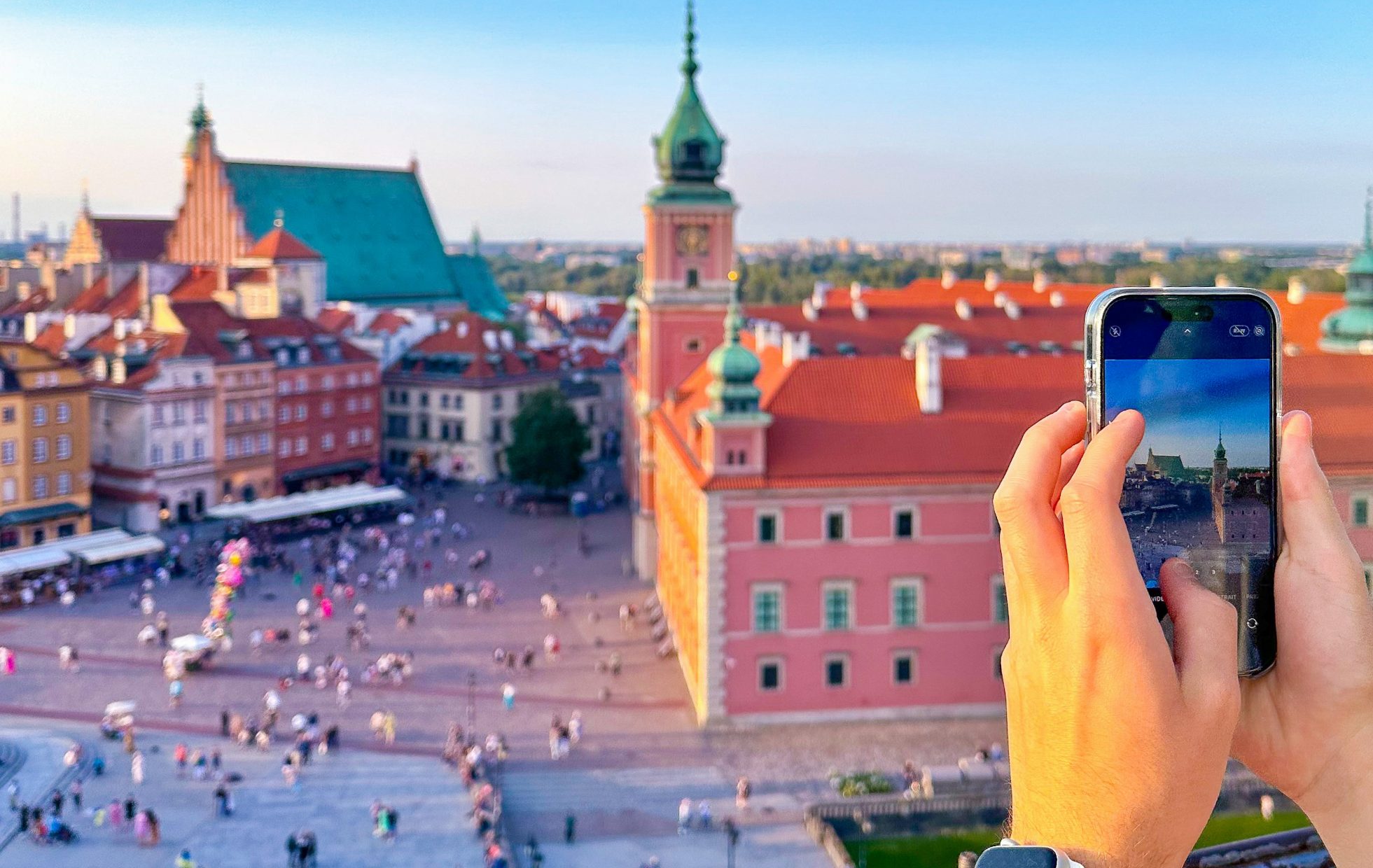 Dłoń trzymająca telefon fotografując Starówkę w Warszawie - instagramowe miejsca w Warszawie