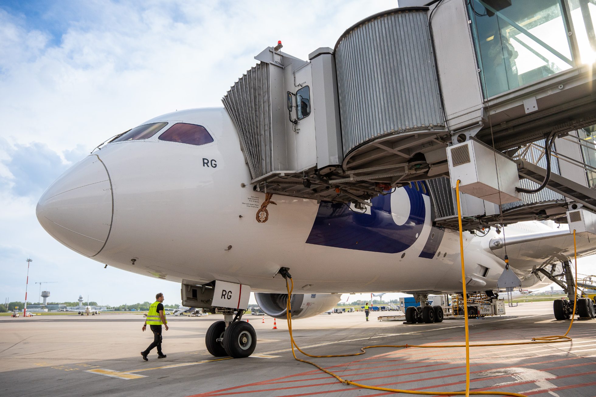 A Boeing 787 Dreamliner at the gate at Chopin Airport, awaiting departure for San Francisco on a slightly overcast day