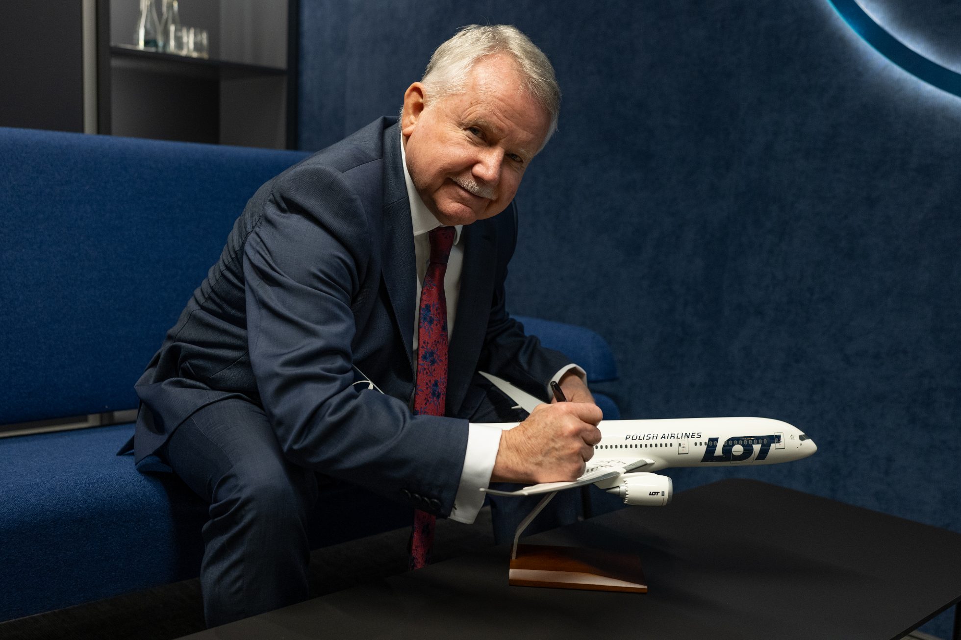 Jerzy Makula stojący z modelem samolotu Dreamliner z jego autografem.