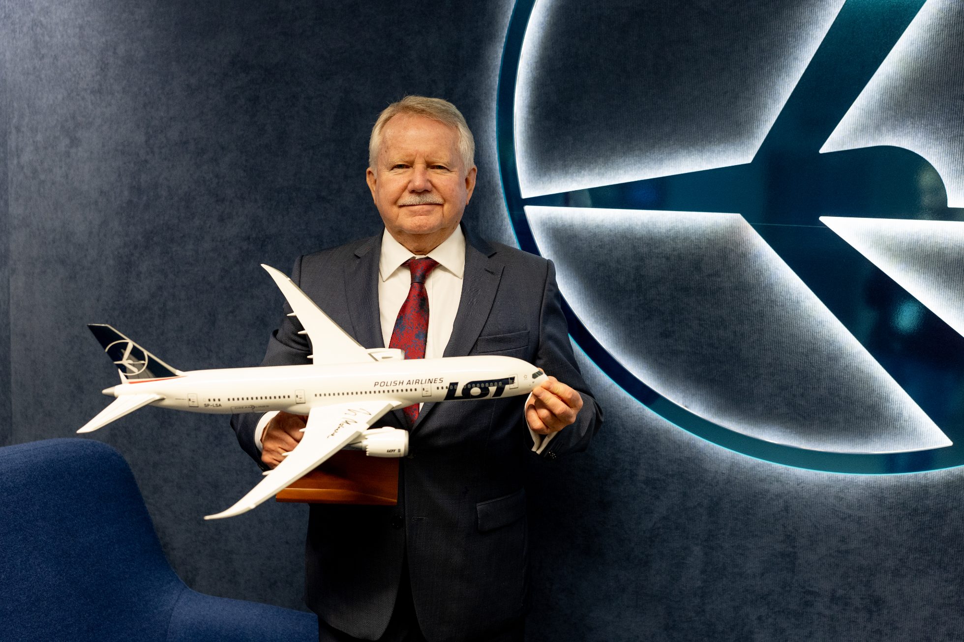 Jerzy Makula stojący z modelem samolotu Dreamliner z jego autografem.