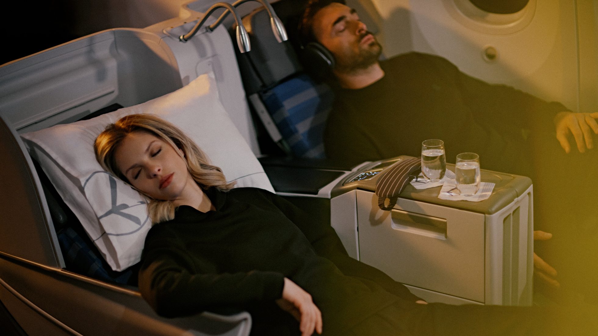 Mężczyzna i kobieta podczas drzemki na rozłożonym do pozycji leżącej fotelu LOT Business Class na pokładzie Dreamlinera