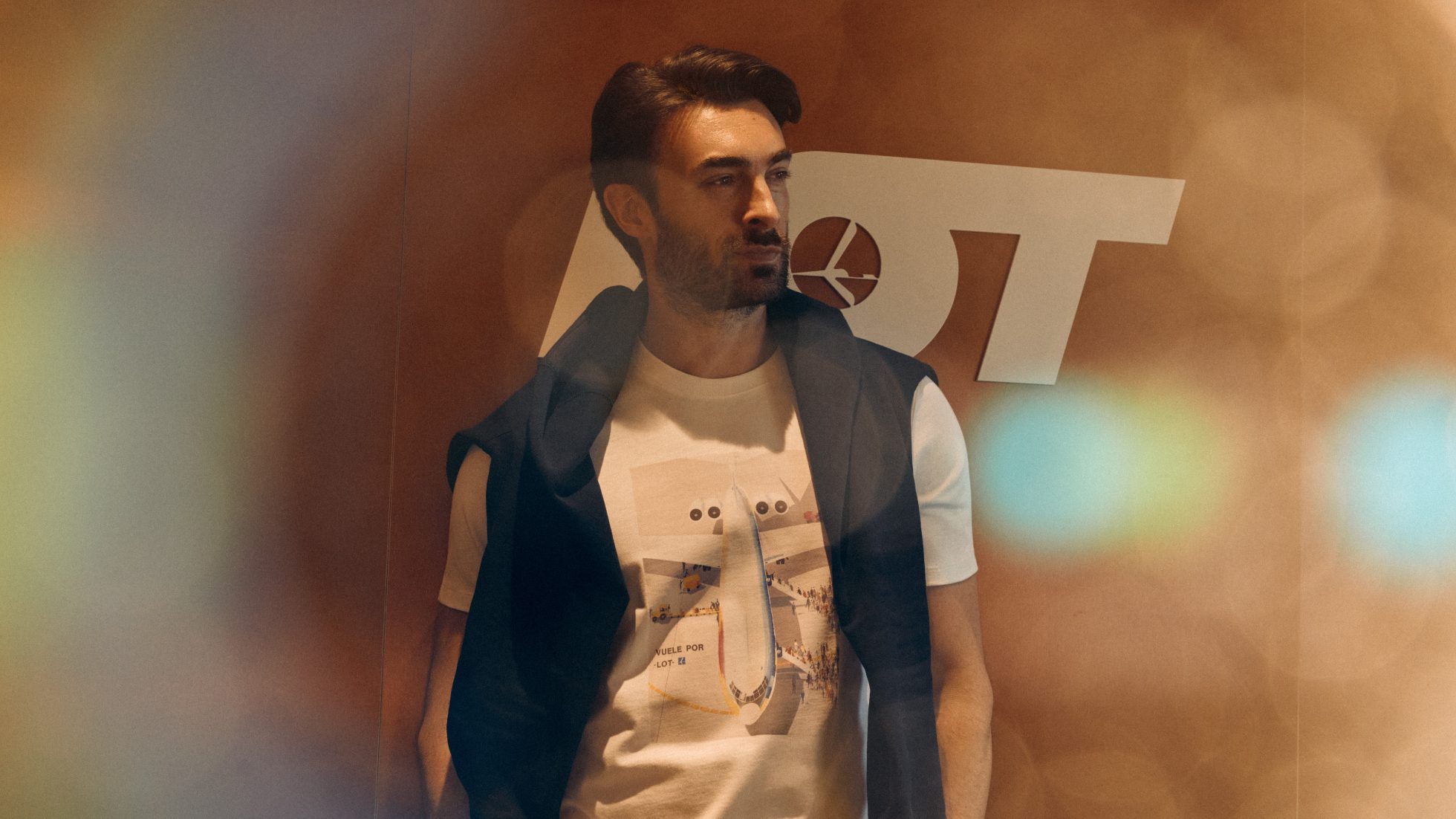 Mężczyzna w białej koszulce z lotniczym motywem