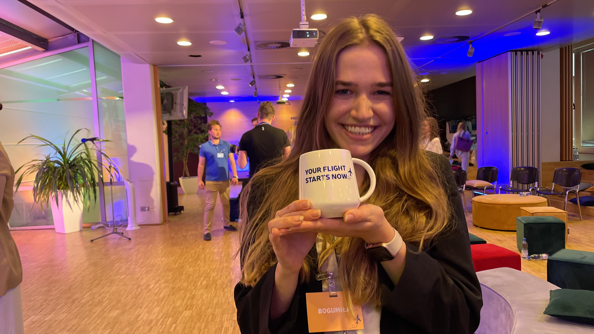 Young woman holding a mug and smiling at the camera