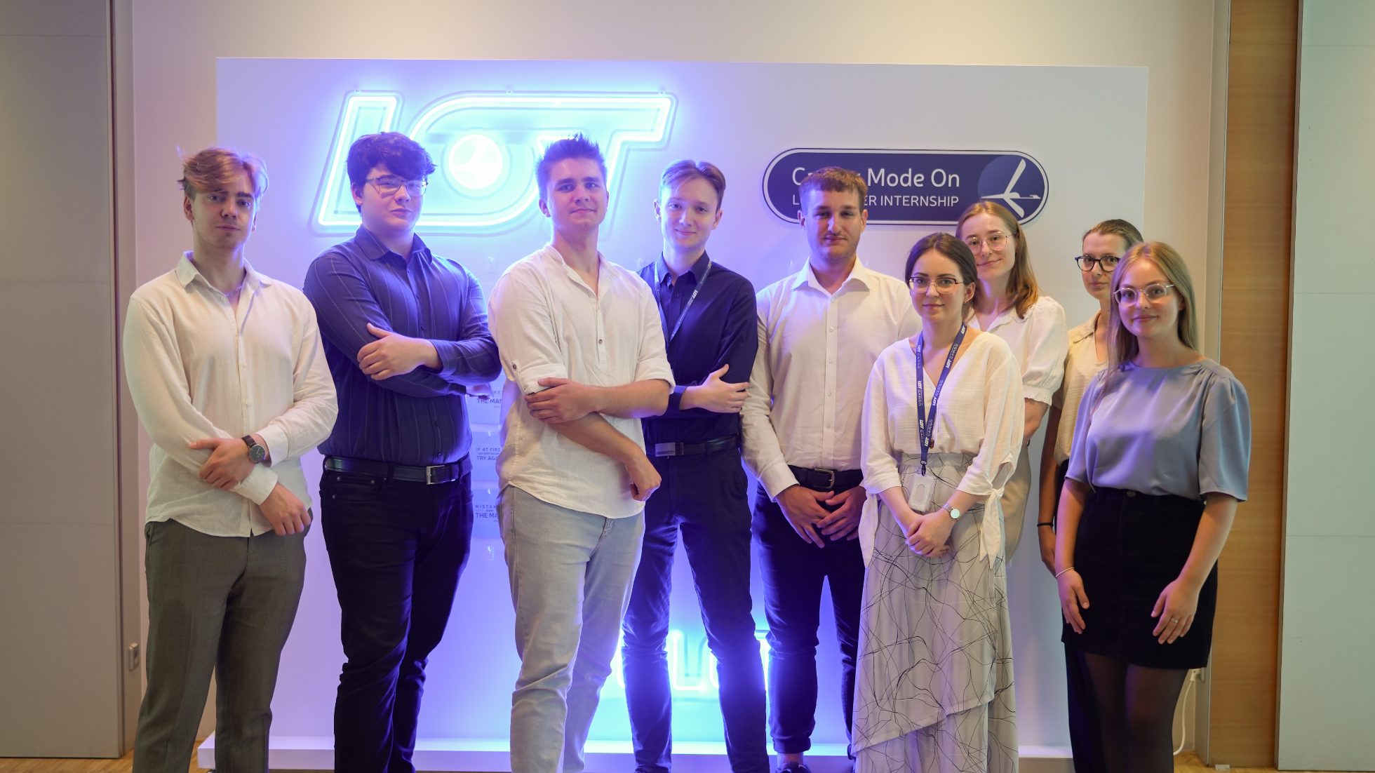Group of people in front of a wall with a neon LOT logo
