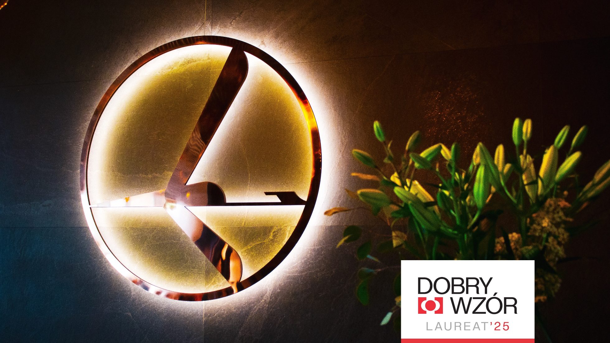 Ścianka z podświetlonym logo żurawia i apla z napisem Dobry Wzór Laureat'25 na białym tle
