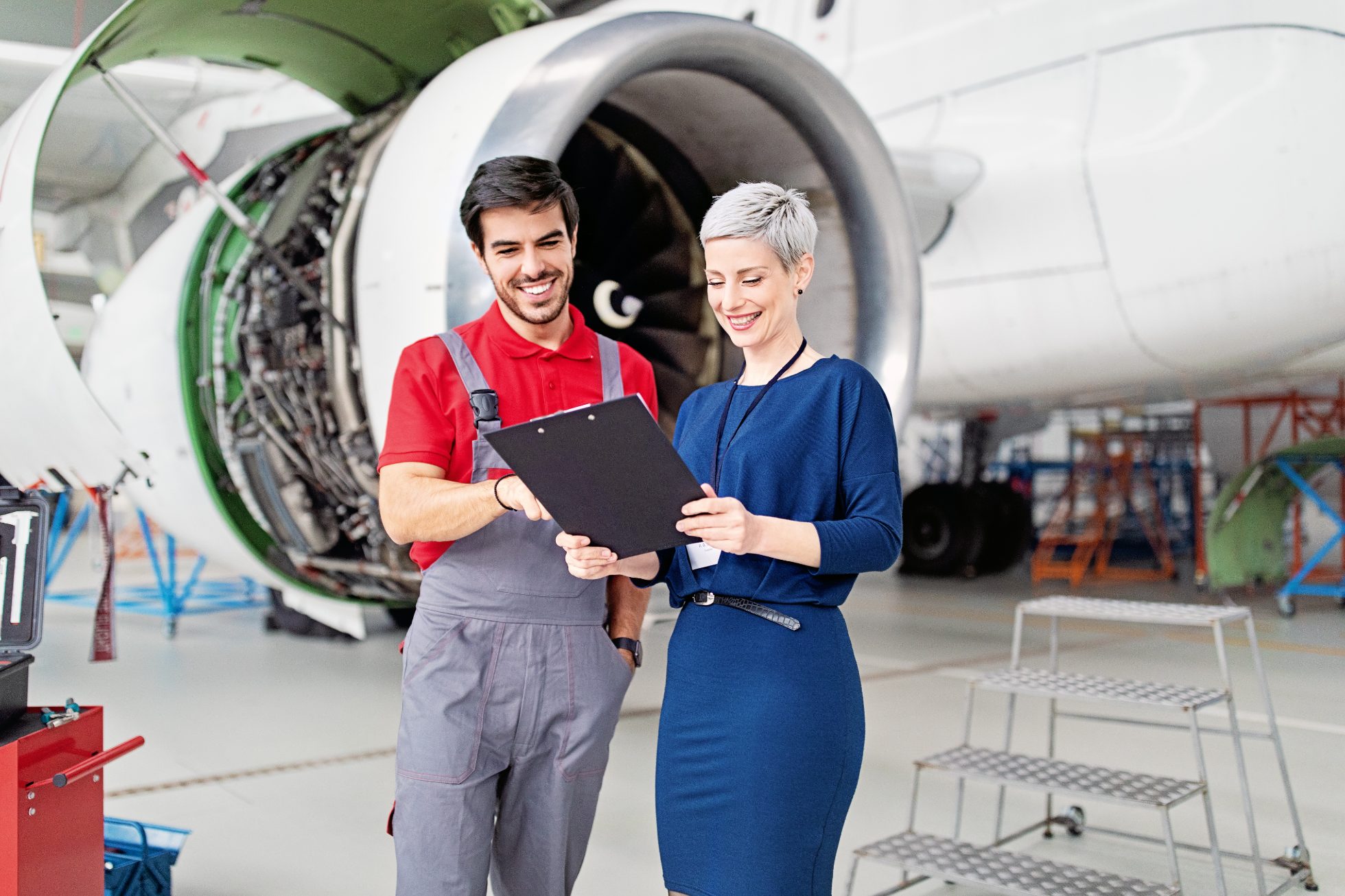 Manager and mechanic in airplane hangar
