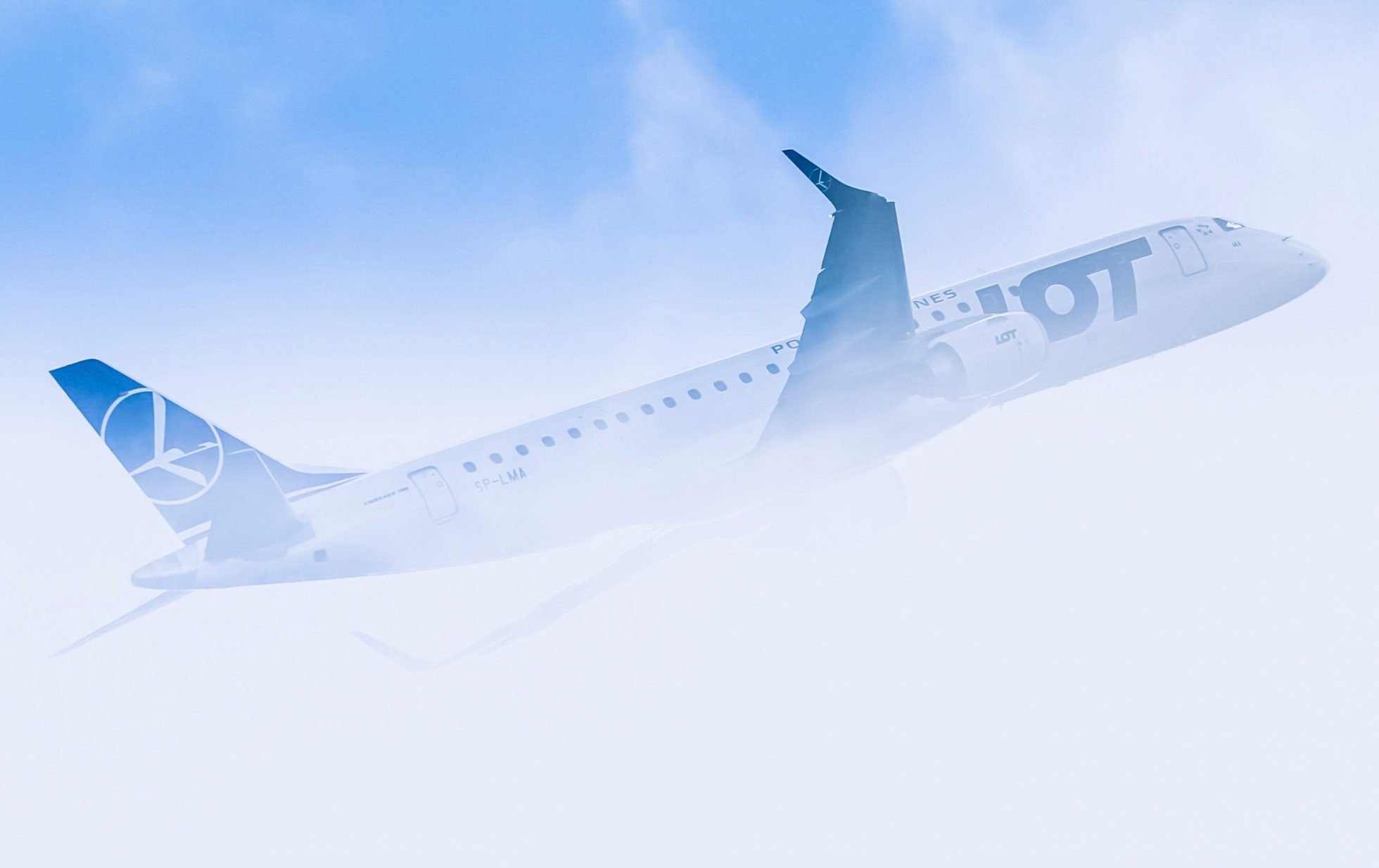 Samolot Embraer na tle chmur.