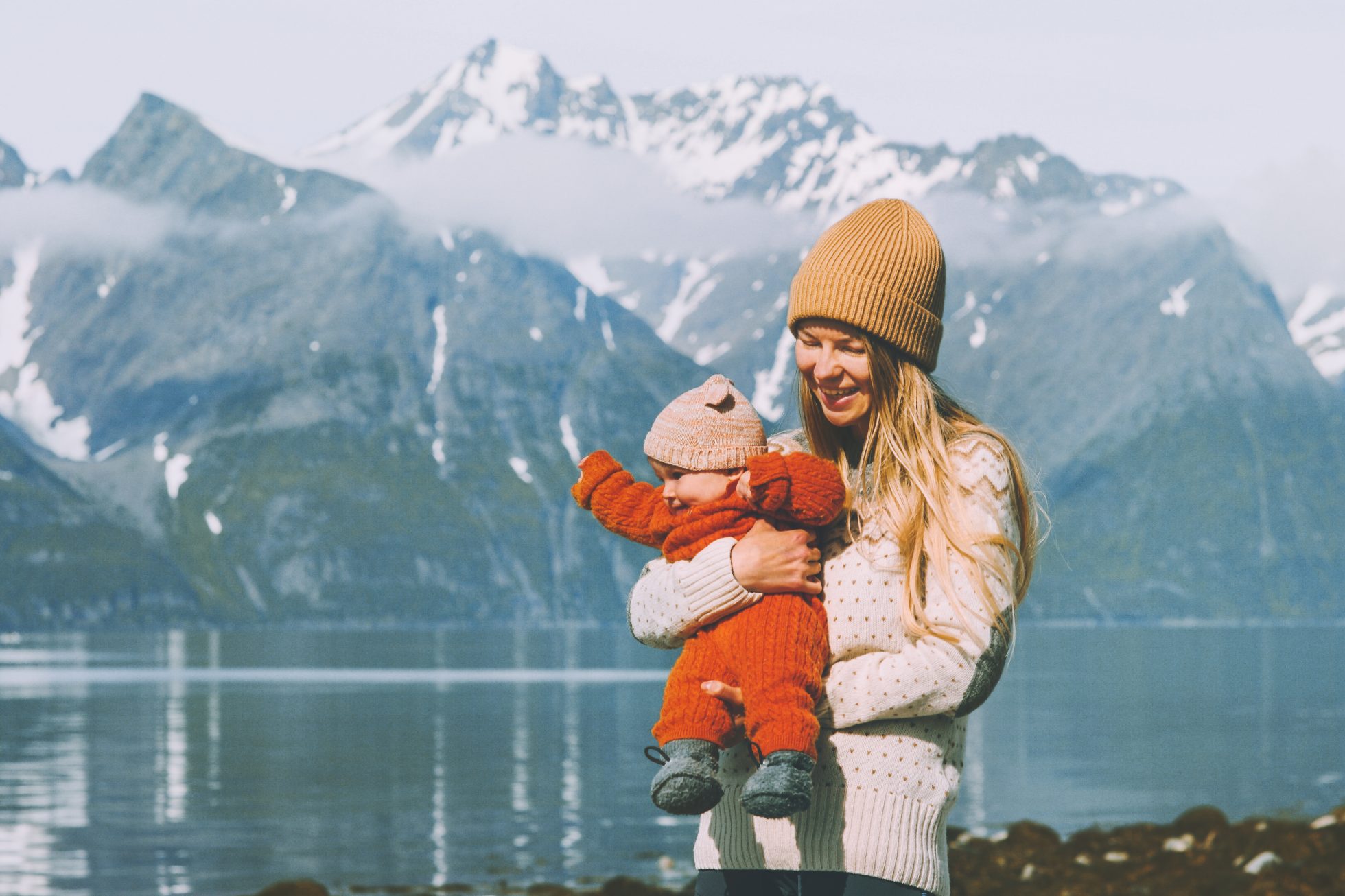 Matka spacerująca z dzieckiem w górach rodzinny styl życia mama trzymająca niemowlę dziecko wakacje macierzyńskie zajęcia na świeżym powietrzu w Norwegii Dzień Matki, co zabrać w góry zimą