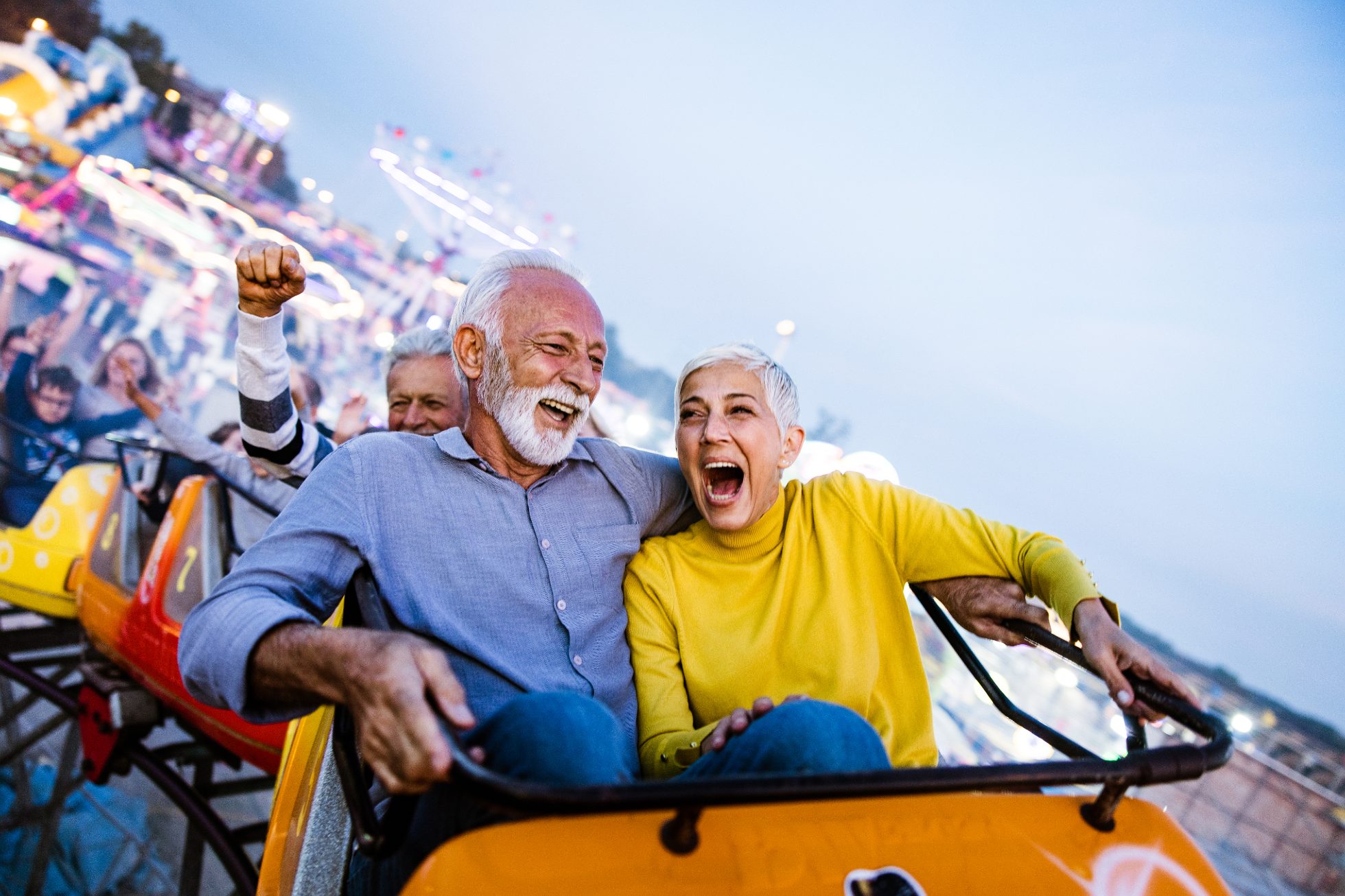 Ludzie na rollercoasterze, doświadczają emocji i adrenaliny.
