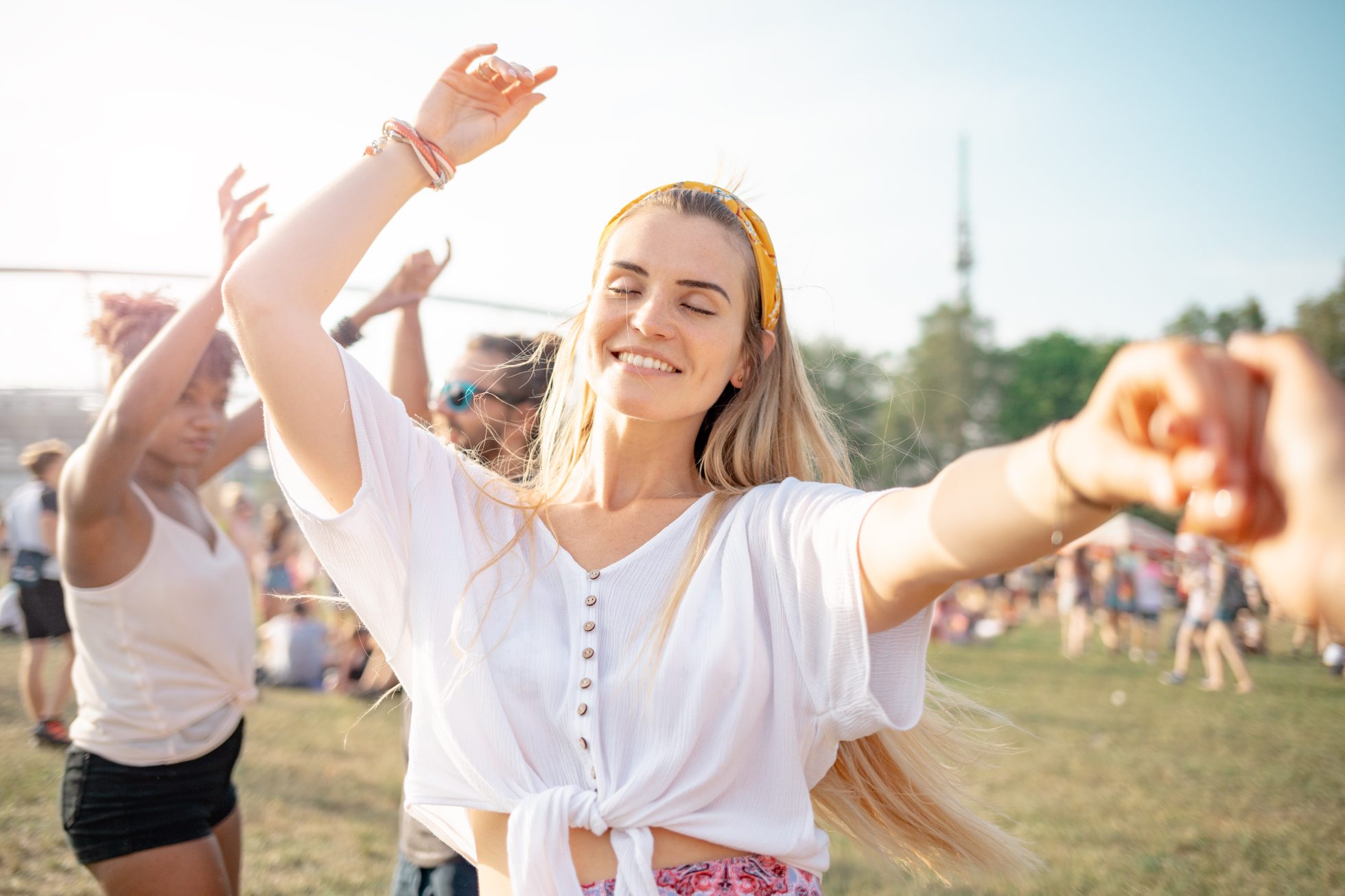 Kobieta na festiwalu muzycznym,w tle tłum ludzi i sceniczne światła.