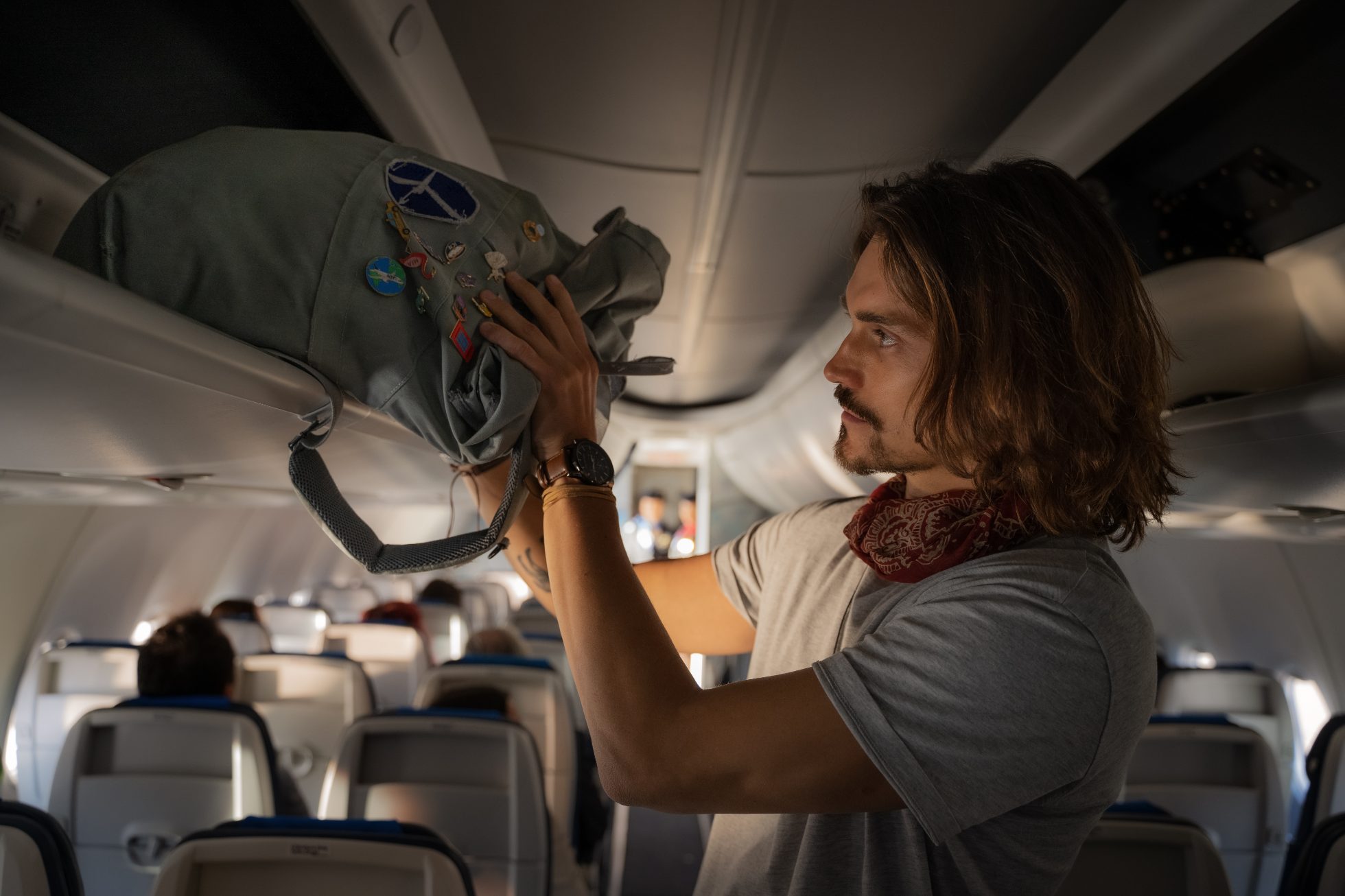 Pasażer chowa bagaż podręczny do schowka nad głową