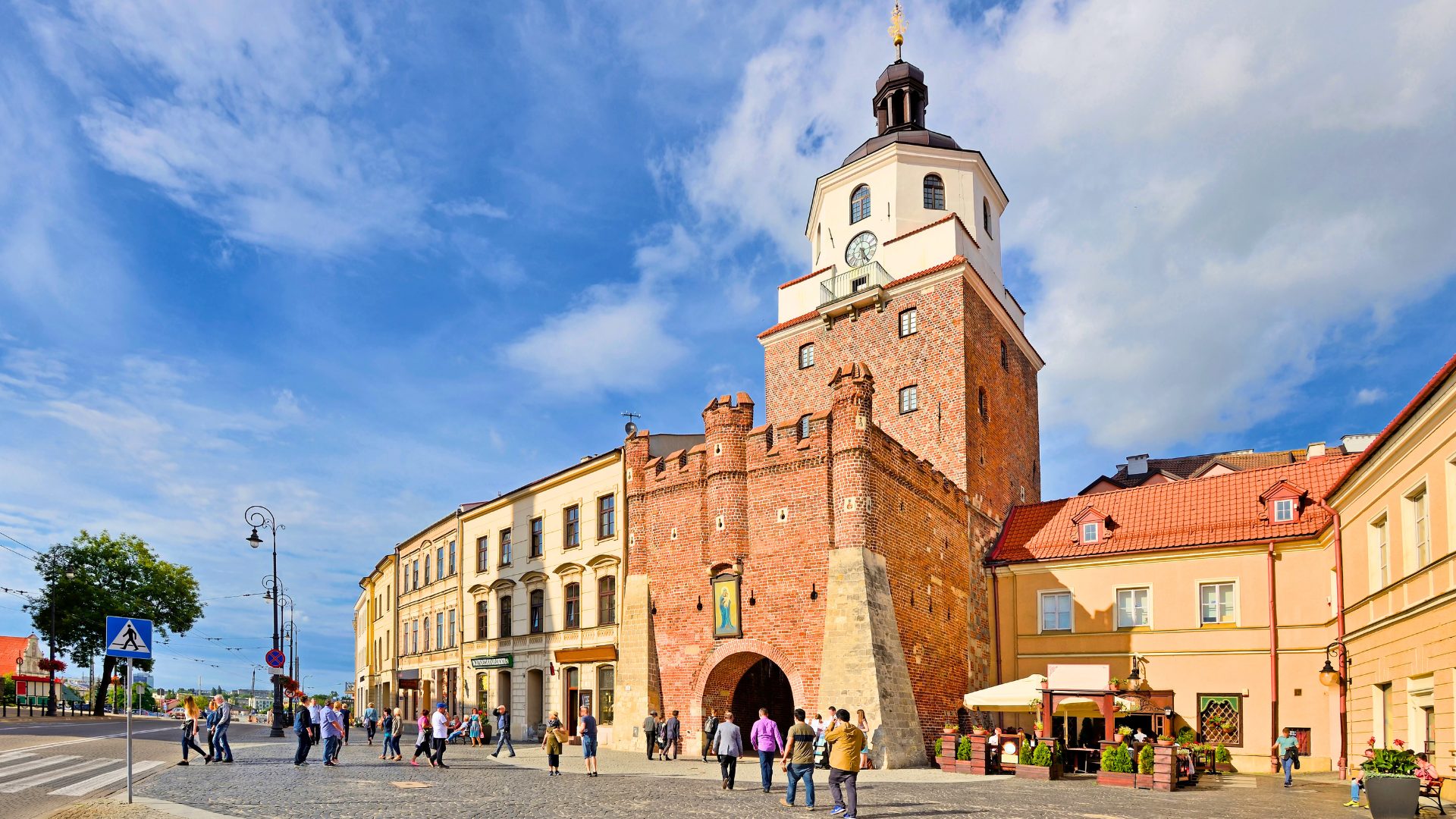 Turyści przechodzący obok Bramy Krakowskiej w Lublinie