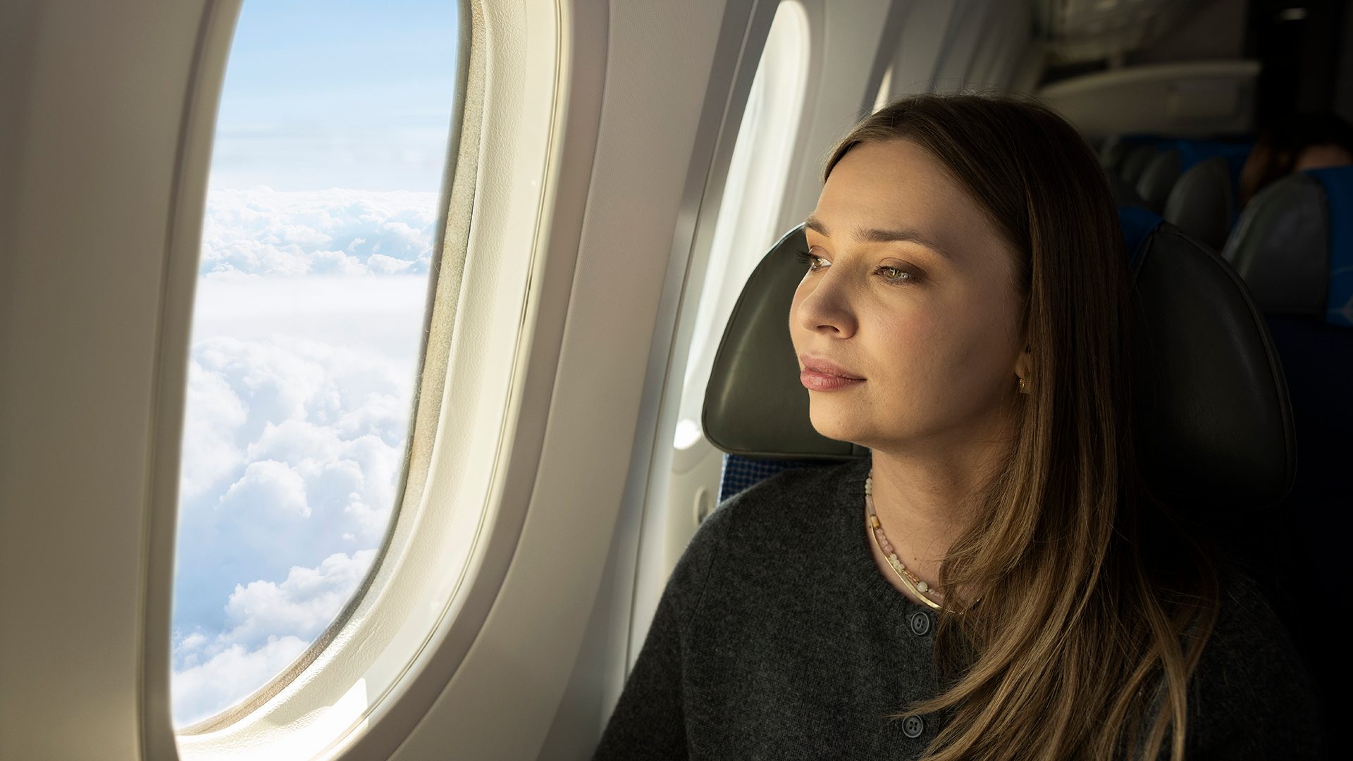 Pasażer spogląda przez okno w samolocie Dreamliner.