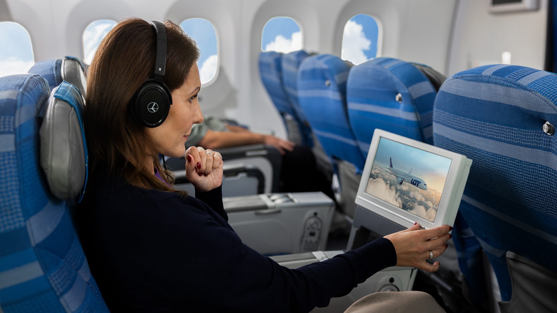 Smiling passengers are enjoying the in-flight entertainment