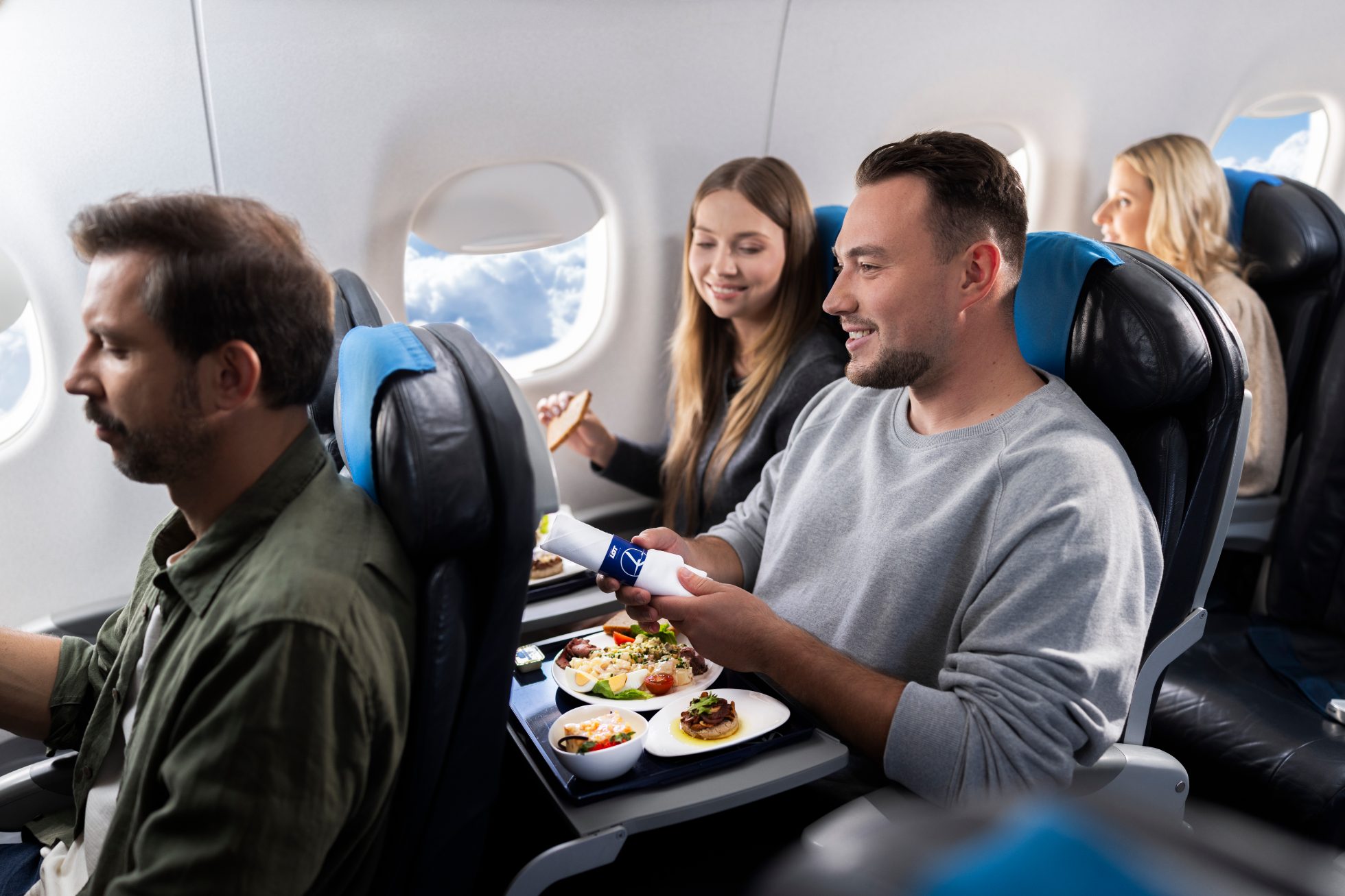 Passengers aboard an Embraer eat a meal