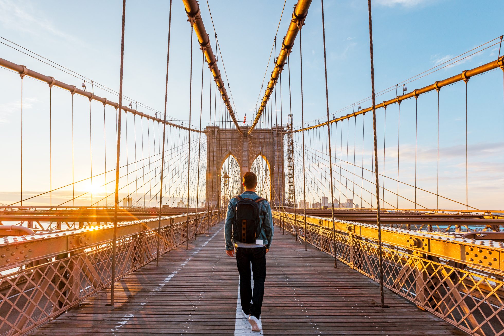 The tourist passes through Brooklyn Bridge at sunrise