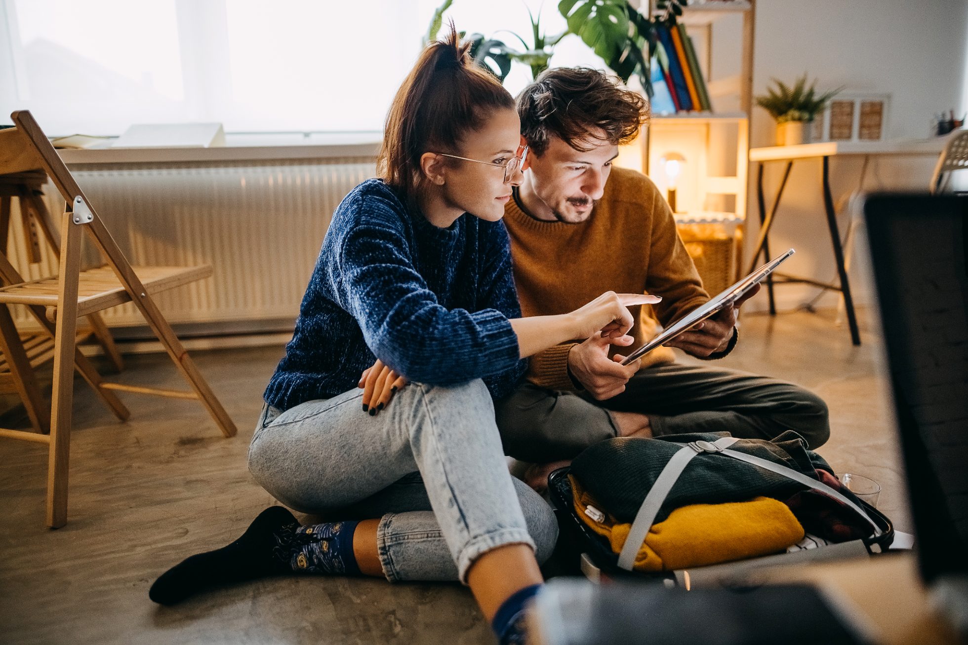 Young couple browse promotional offers for cheap flights by plane. How to fly cheaply?