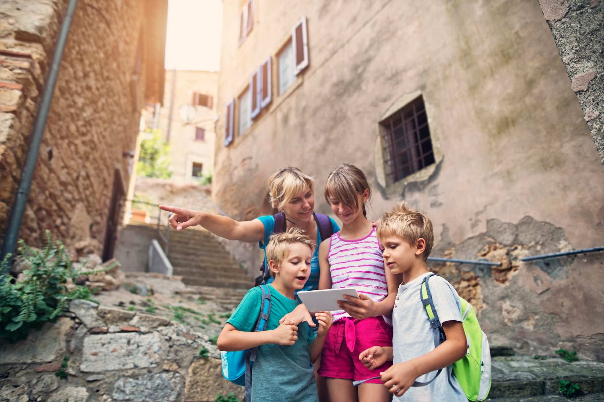 Kids tourists with mother visiting beautiful Italian village in Tuscany.